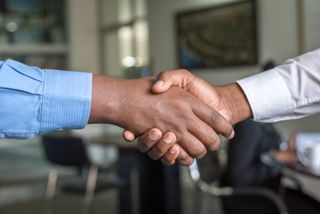 Two professionals shaking hands after a successful accounting firm client engagement meeting.